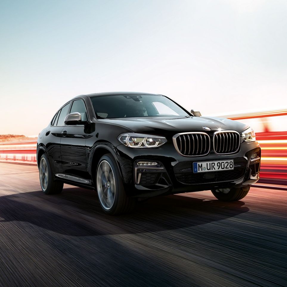 BMW X4 M40i and BMW X4 M40d, three-quarter front view. BMW X4 M40i and BMW X4 M40d in Black Sapphire metallic, exterior, three-quarter front view, left side with light strips.