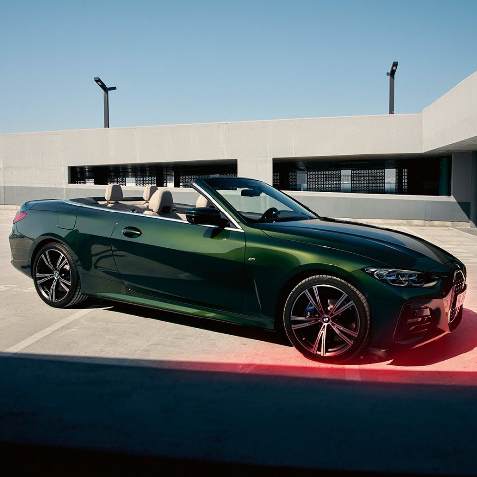 正面四分之三之角度視圖 BMW 4 Series Convertible G23 2020 與一名男士 BMW 4 Series Convertible G23 Sanremo Green 金屬外觀漆面 2020 正面四分之三之角度視圖旁邊有一位男士