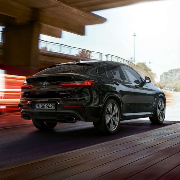 BMW X4 M40i,四分之三正面視圖。 BMW X4 M40i,藍寶石黑金屬,行駛中,外觀設計,四分之三正面視圖,帶燈條。