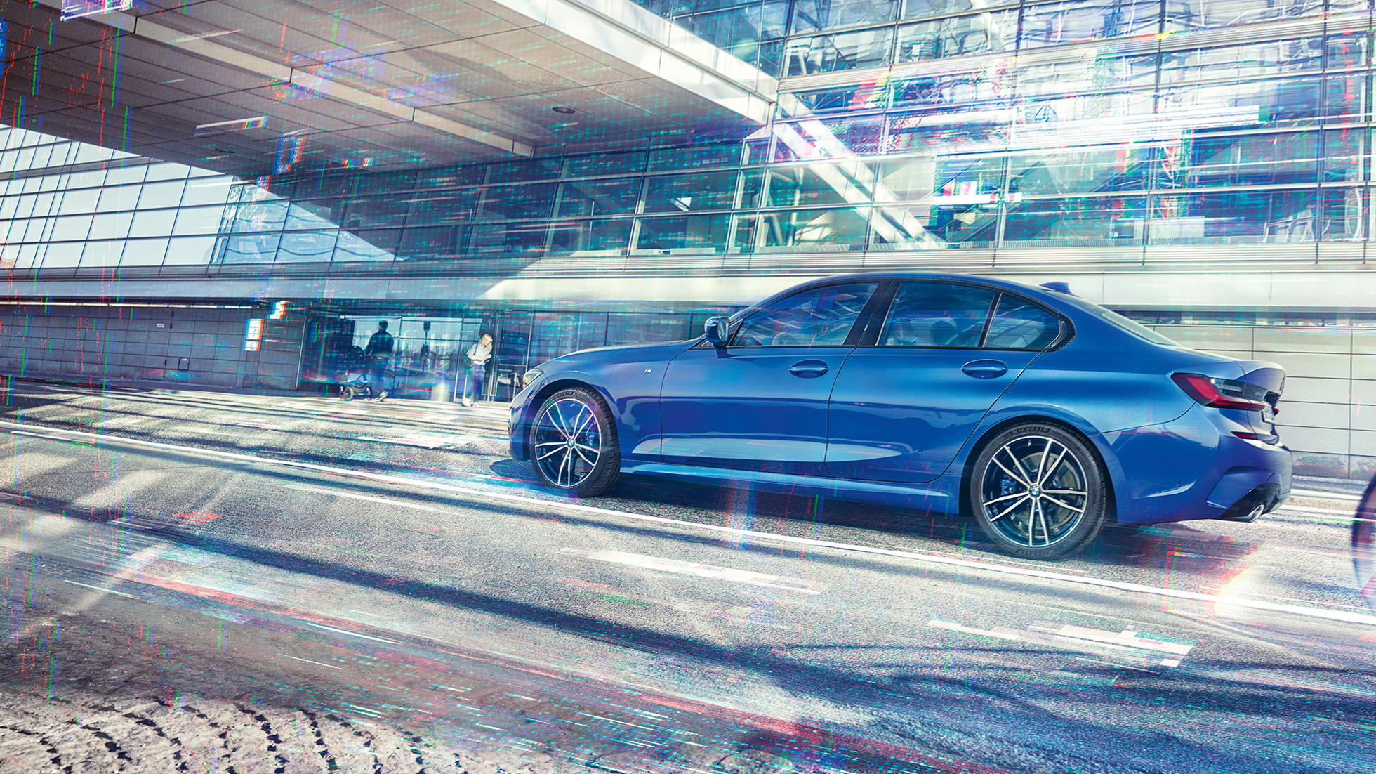 BMW 3 Series Sedan,側視圖 BMW 3 Series Sedan 日間側面靜態影像,位於一棟玻璃建築物前方。
