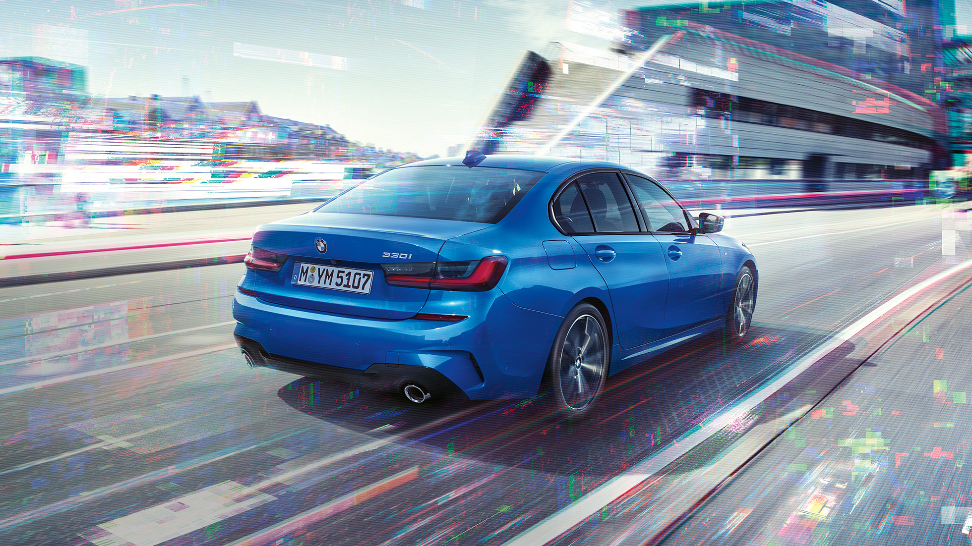 BMW 3 Series Sedan,側面后視圖 BMW 3 Series Sedan 後部四分之三角度影像,位於白天城市背景前。