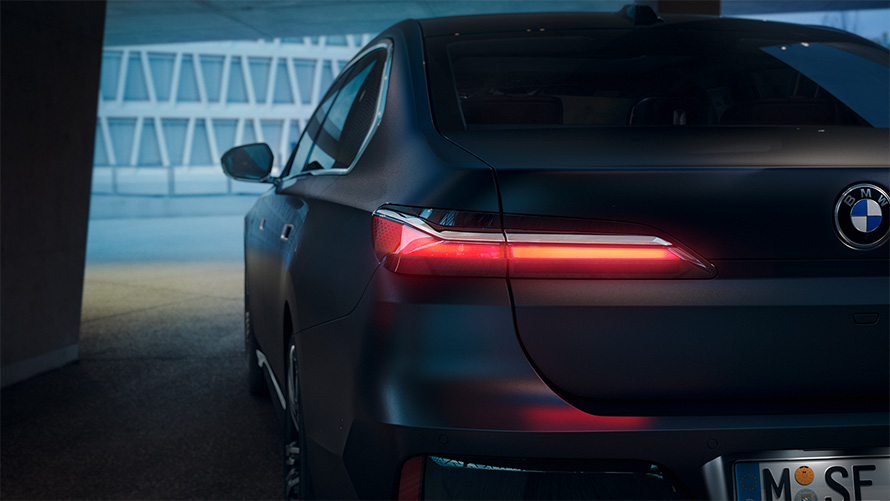 BMW 7 Series Sedan G70 ICE 740i M sports package Frozen Deep Grey metallic rear view with red glowing taillight in tunnel