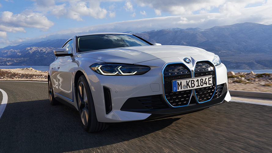 Three-quarter front view BMW i4 eDrive40 G26 2021 driving BMW i4 eDrive40 G26 2021 Mineral White three-quarter front view driving