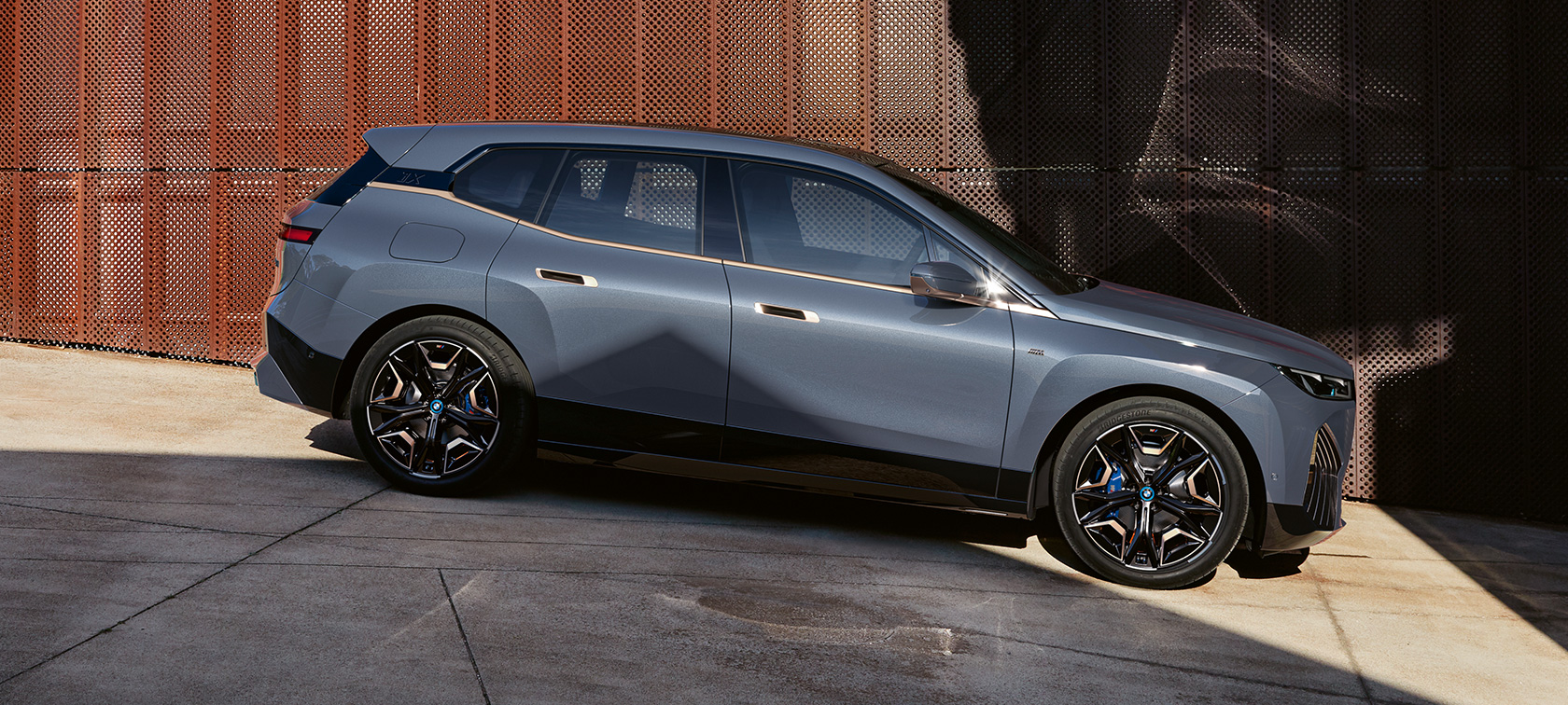 BMW iX M60 i20 2022 electric SUV BMW Individual Storm Bay metallic side view parking BMW iX M60 i20 2022 electric SUV BMW Individual Storm Bay metallic side view parking