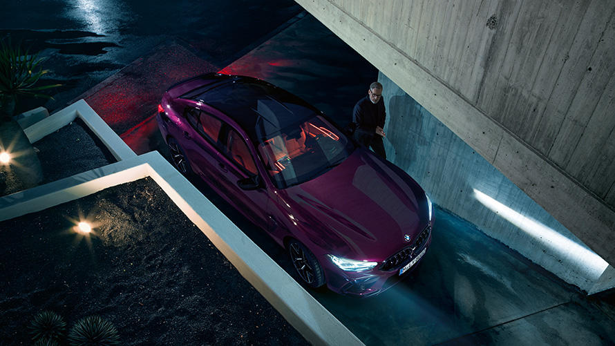 BMW M8 Competition Gran Coupé birds-eye view BMW M8 Competition Gran Coupé BMW Individual Ametrine metallic standing in front of a building birds-eye view