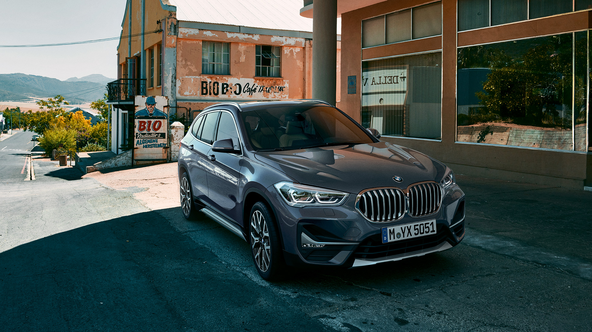 BMW X1, three-quarter front view. BMW X1, three-quarter front view standing in front of urban scenery.