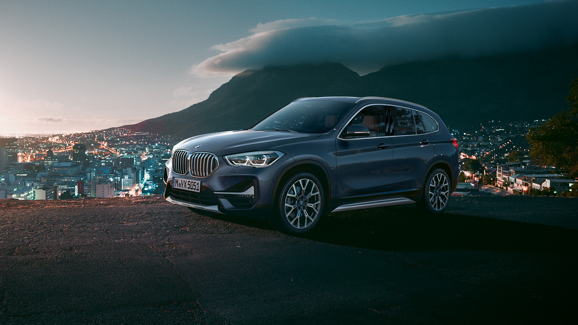 BMW X1, three-quarter side view. BMW X1, three-quarter side view standing in front of urban scenery.
