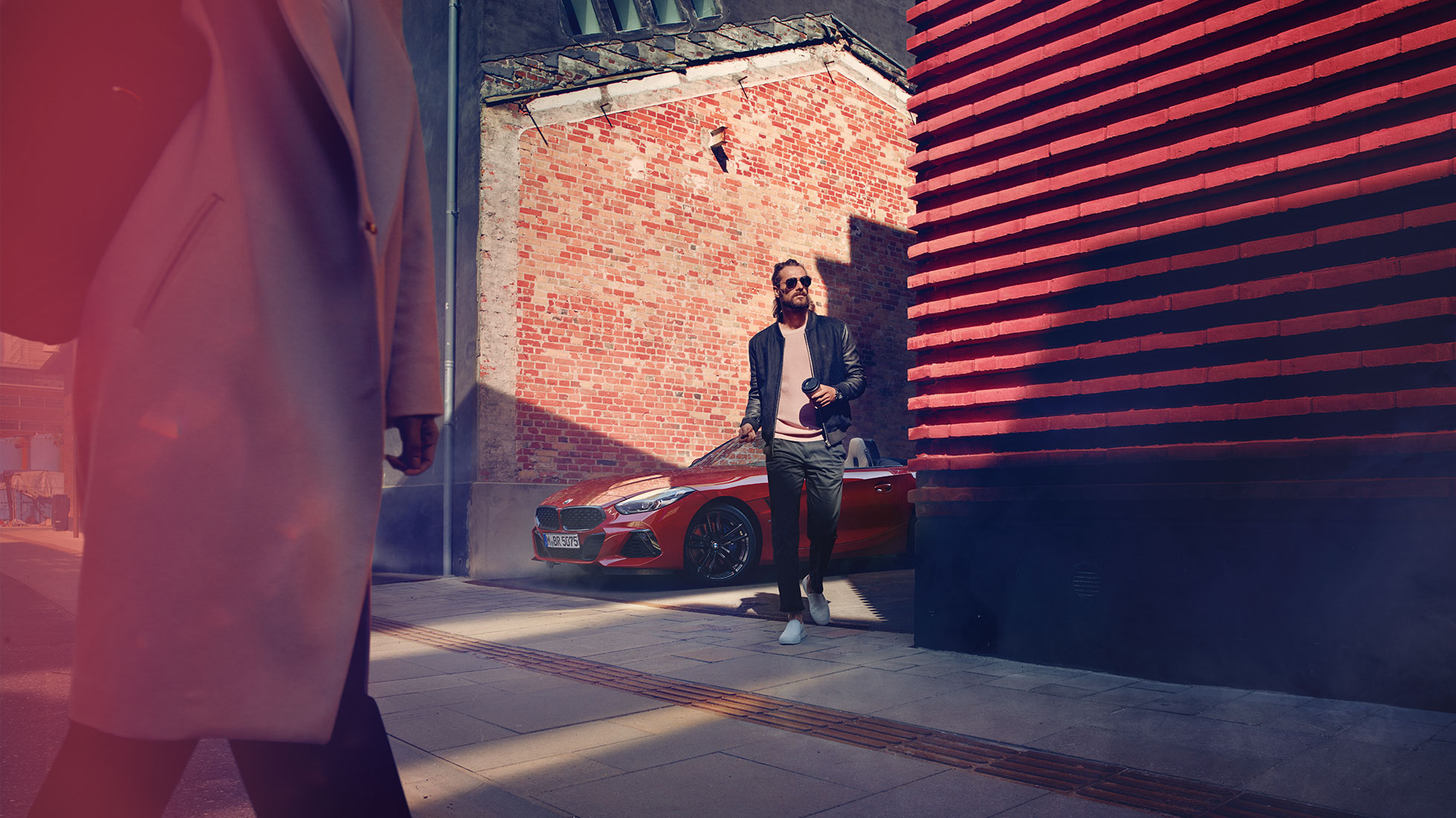 小巷里的 BMW Z4 Roadster 男士站在小巷里的 BMW Z4 Roadster 前