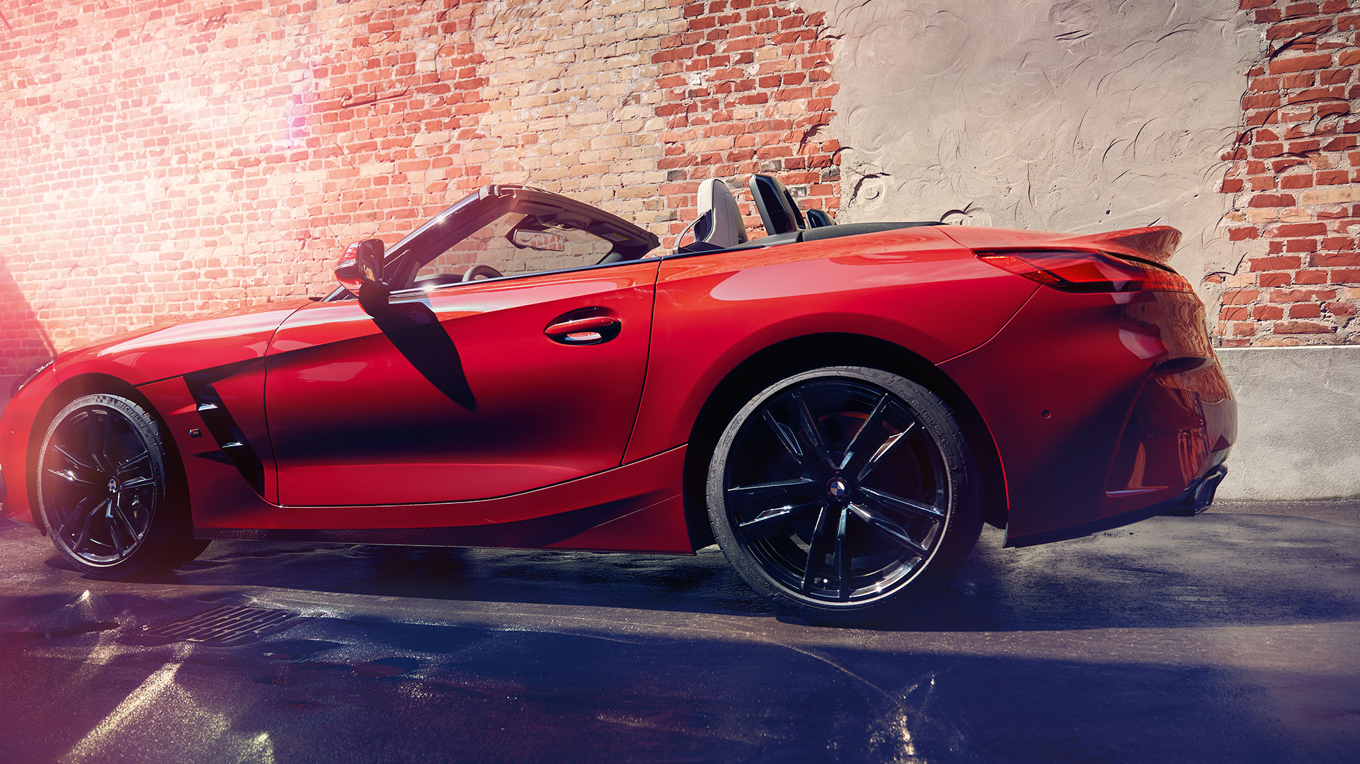 BMW Z4 Roadster 的側面拍攝 磚墻前的 BMW Z4 Roadster 的側面拍攝