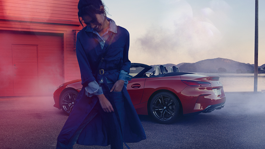 BMW Z4 M40i Roadster G29 軟頂打開 BMW Z4 M40i Roadster G29 尾部四分之三之角度視圖軟頂打開,前方有一名女士
