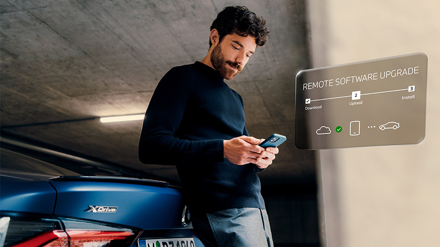Remote Software Upgrade Man leaning against BMW rear and looking at his smartphone